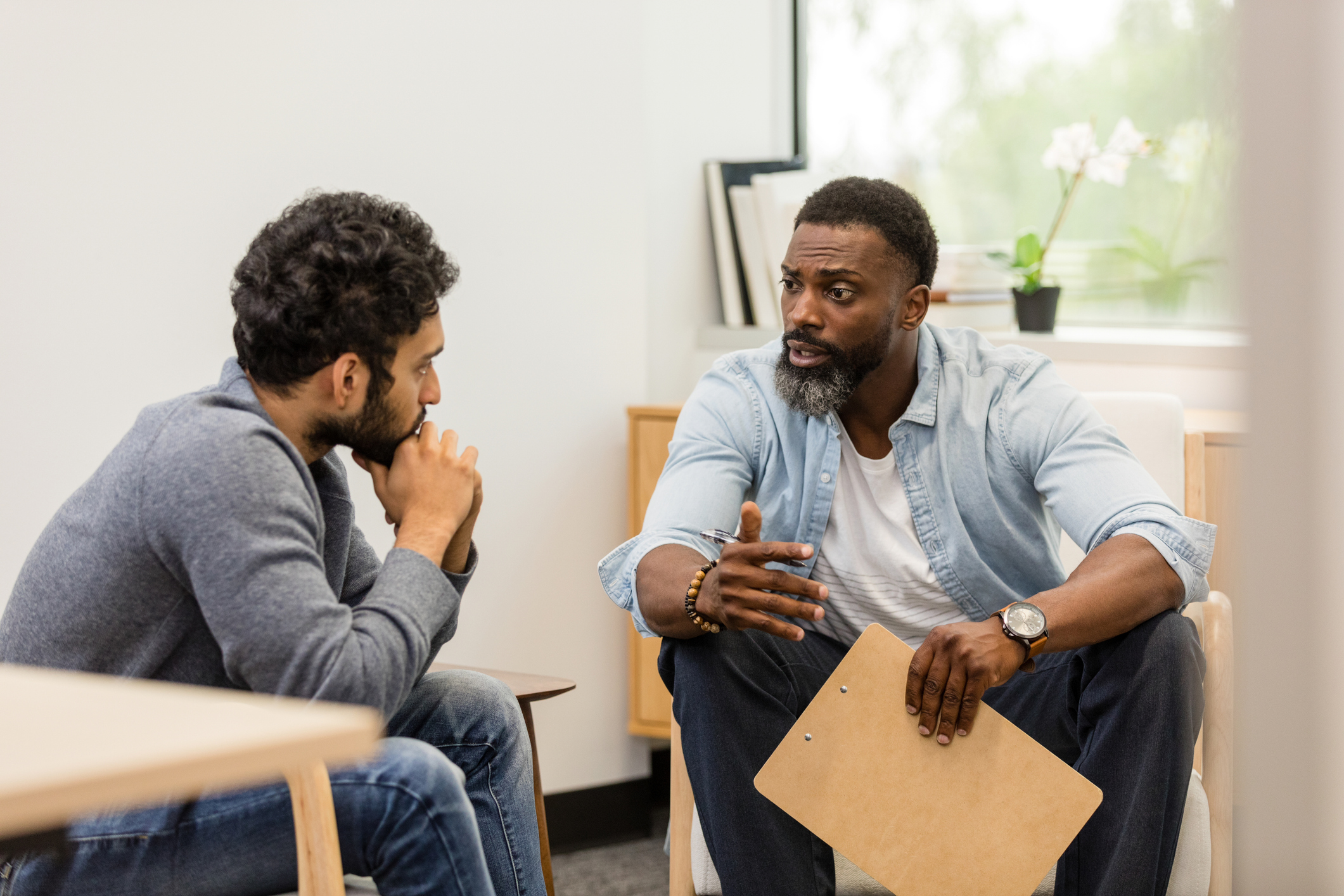 Black male therapist gives advice to a substance abuse patient working on their recovery