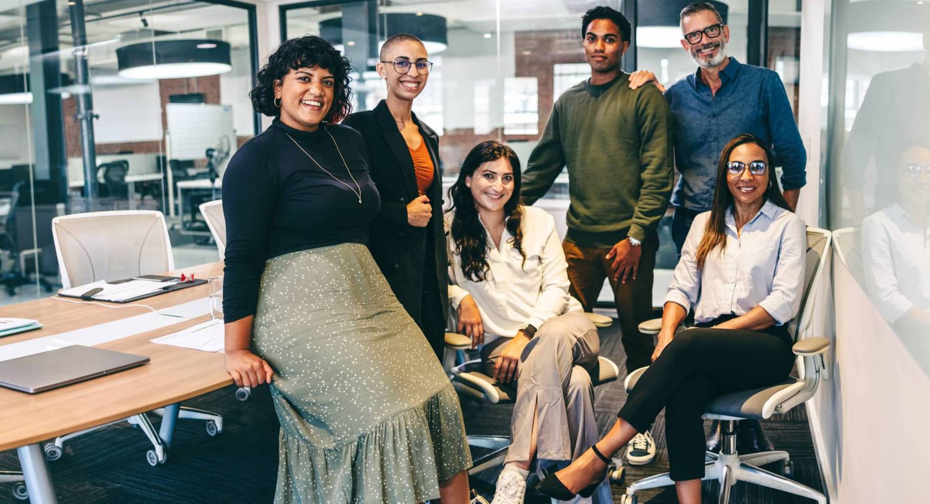 A diverse team of cheerful businesspeople smiling at the camera in a boardroom