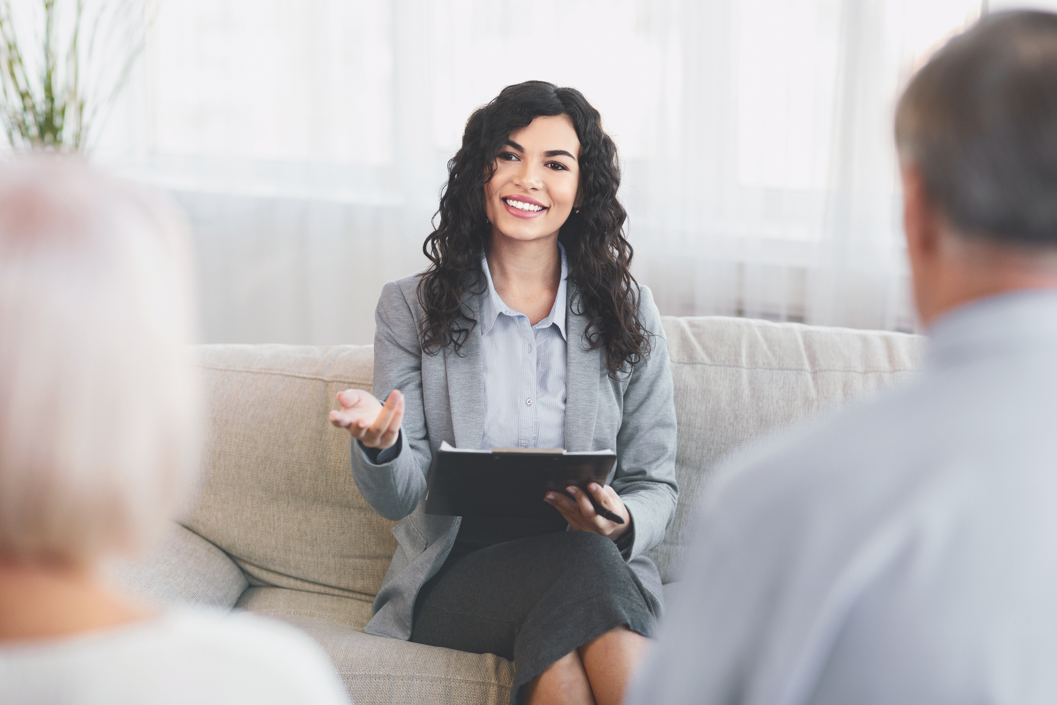 A Latina psychologist smiles during a couples counseling session.