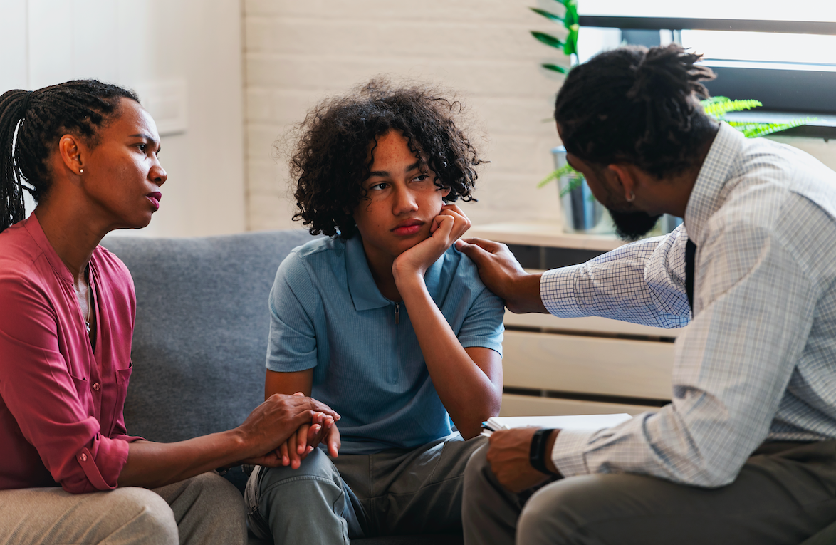 African American woman with a teen son has a meeting with a psychologist