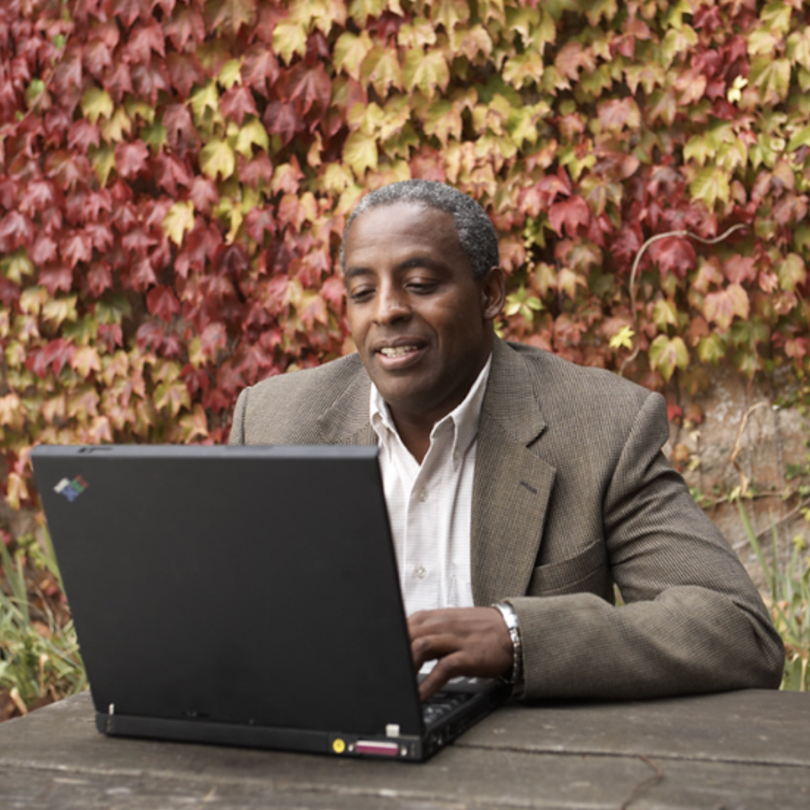 man on a computer sitting outsite