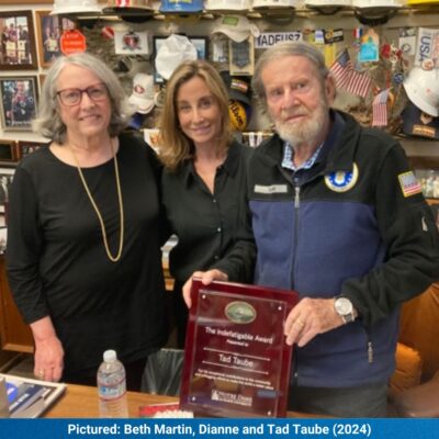 Ted Taube holding award with 2 other people.
